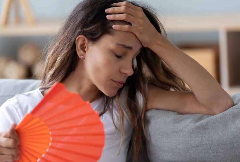 Parker-Heating-and-Air-Conditioning-woman-feeling-warm-using-fan